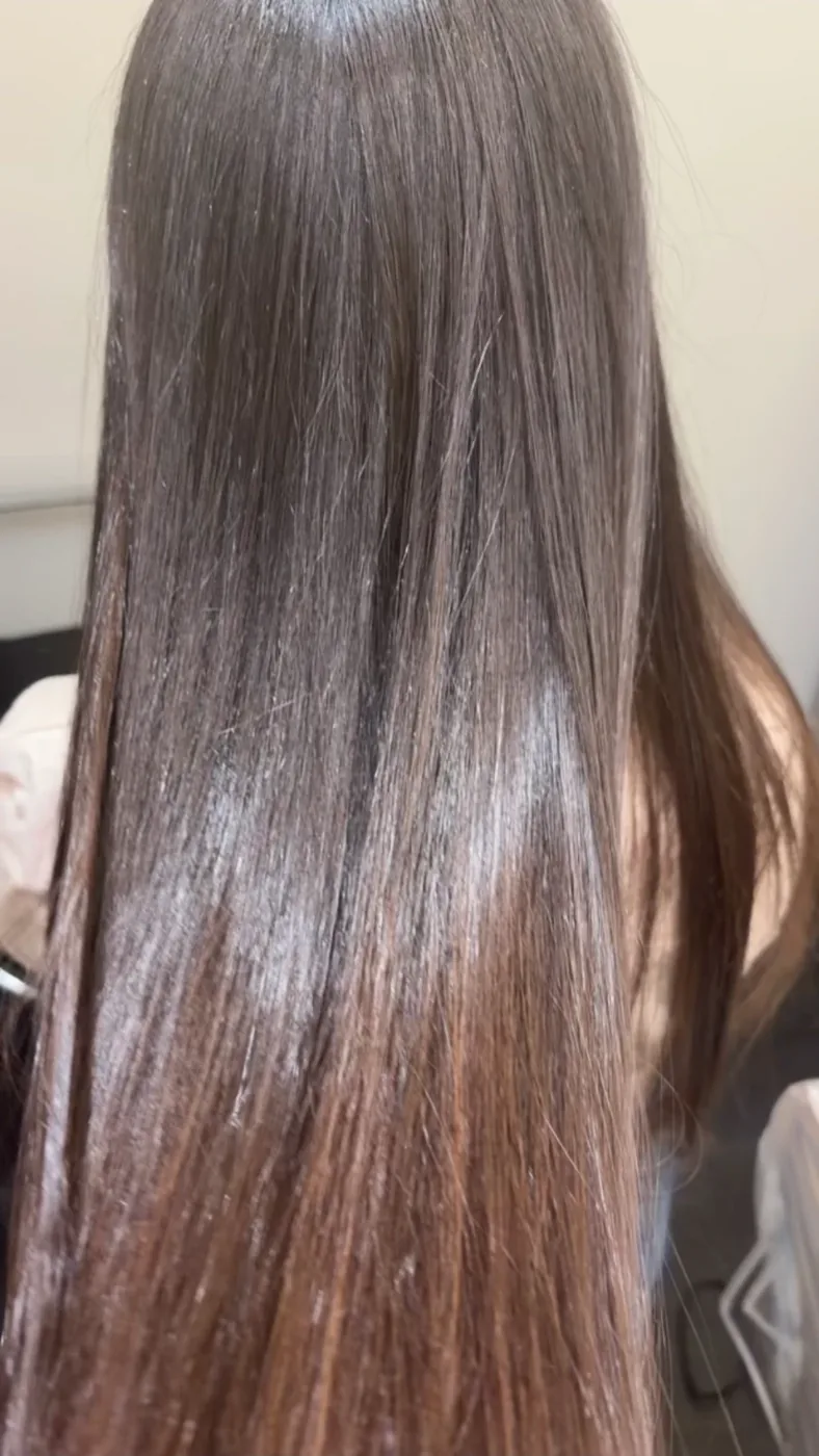 Long glossy brunette hair with a warm caramel melt through the ends, styled at Hair by Ramo