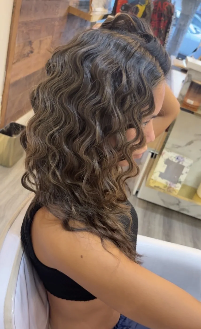 Bronde balayage set in beachy waves, half pinned up